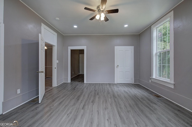 unfurnished bedroom with ceiling fan, hardwood / wood-style flooring, and ornamental molding