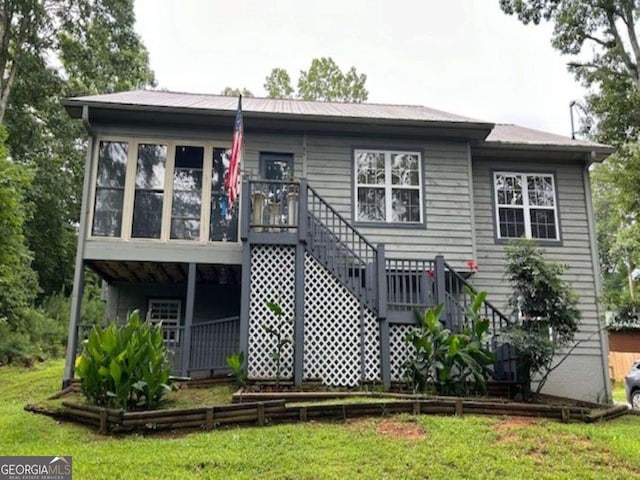 back of property with stairs and a lawn