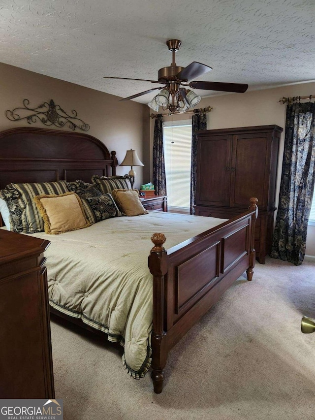 bedroom with light carpet, ceiling fan, and a textured ceiling