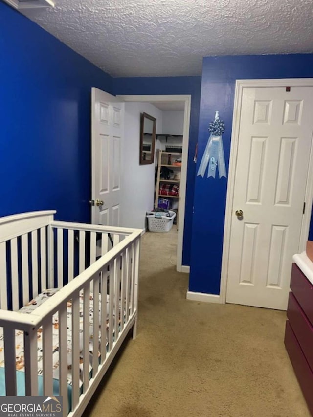 bedroom featuring carpet floors, a textured ceiling, and baseboards