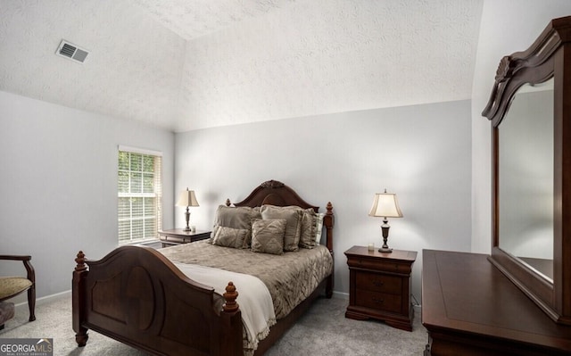 bedroom with light colored carpet and a textured ceiling