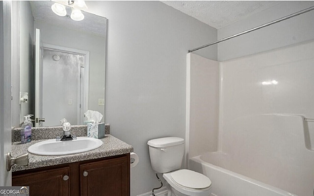 full bathroom featuring vanity, toilet,  shower combination, and a textured ceiling