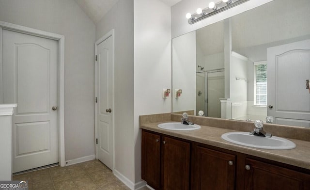 bathroom featuring an enclosed shower, vanity, and vaulted ceiling