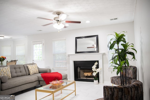 living room with ceiling fan and a textured ceiling