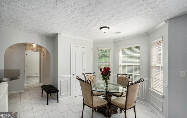 dining room with crown molding and a textured ceiling