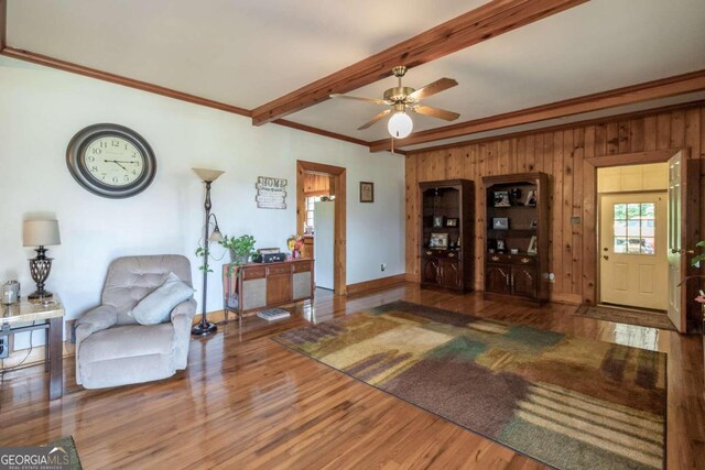 living room with hardwood / wood-style flooring, beam ceiling, and ceiling fan