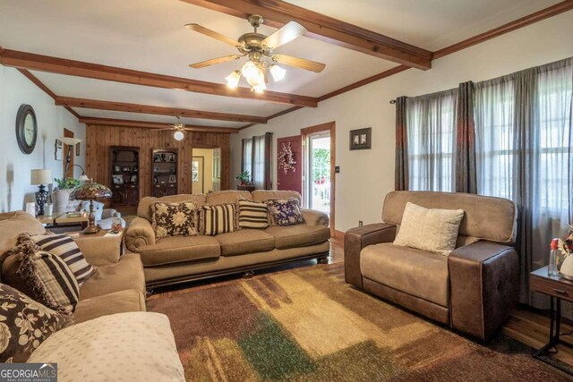 living room with beam ceiling, ceiling fan, and wooden walls