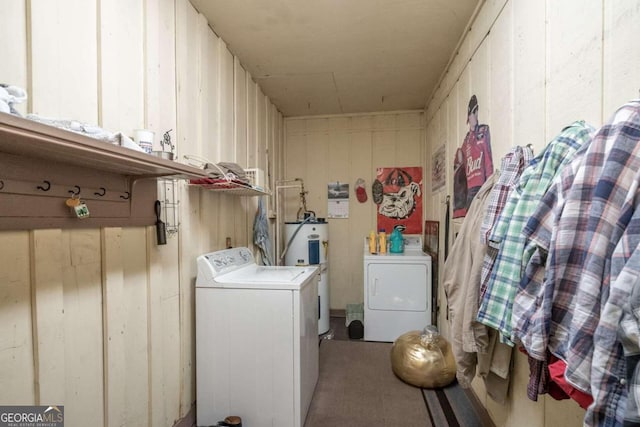 clothes washing area featuring water heater and washer and clothes dryer