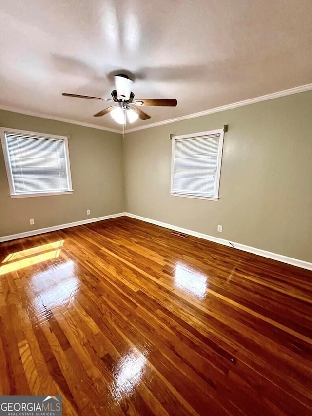 spare room with crown molding, ceiling fan, and wood-type flooring