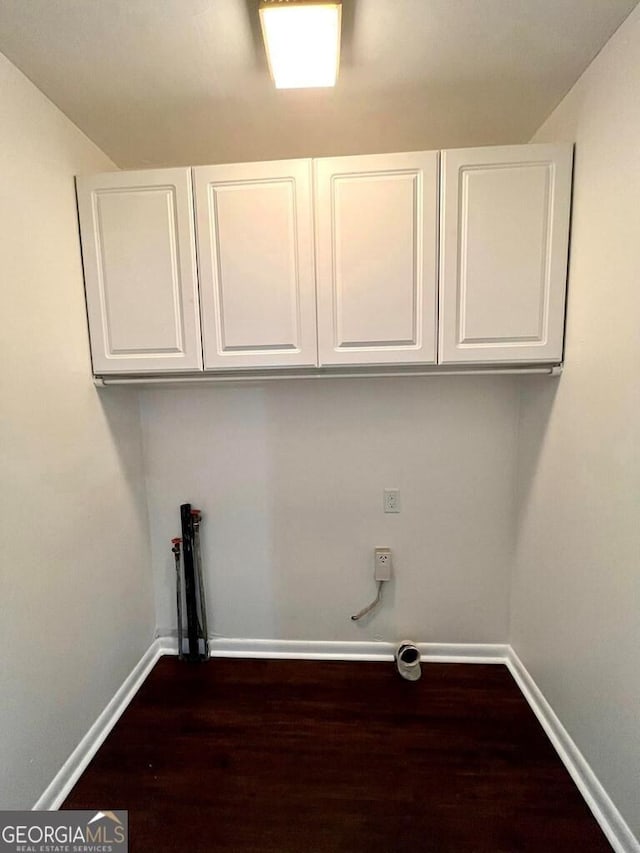 washroom featuring washer hookup, dark hardwood / wood-style floors, and cabinets