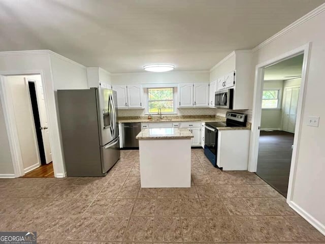 kitchen featuring sink, white cabinetry, plenty of natural light, stainless steel appliances, and a center island