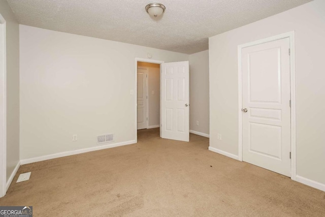 unfurnished bedroom with light carpet and a textured ceiling