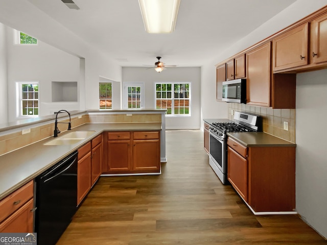 kitchen featuring dark hardwood / wood-style floors, sink, backsplash, ceiling fan, and stainless steel appliances