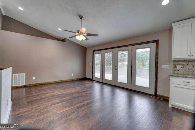 unfurnished living room featuring lofted ceiling, dark wood-type flooring, and ceiling fan