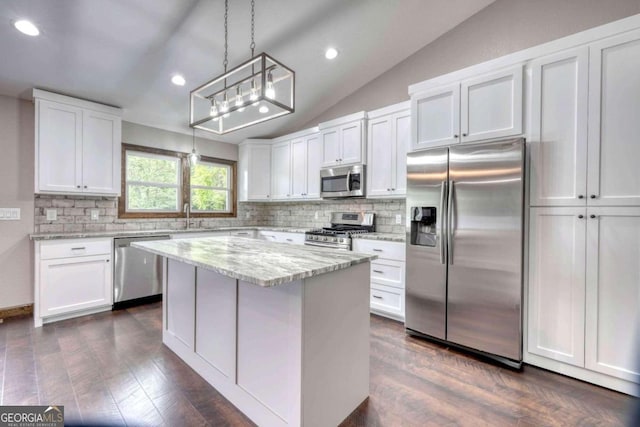 kitchen with appliances with stainless steel finishes, a center island, white cabinets, and decorative light fixtures