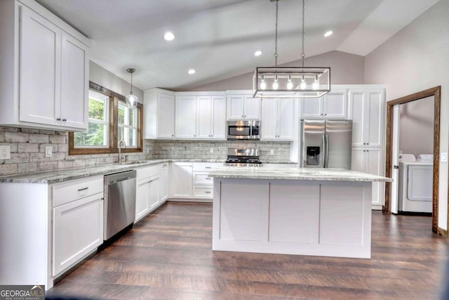 kitchen featuring pendant lighting, white cabinetry, washing machine and clothes dryer, and appliances with stainless steel finishes