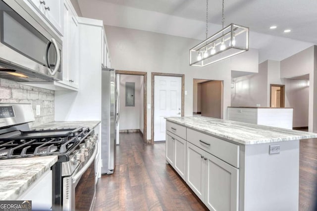 kitchen featuring pendant lighting, appliances with stainless steel finishes, light stone counters, and white cabinets