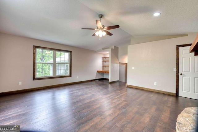 unfurnished living room with vaulted ceiling, dark wood-type flooring, ceiling fan, and a textured ceiling