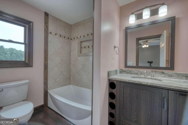 full bathroom featuring tiled shower / bath combo, vanity, and toilet