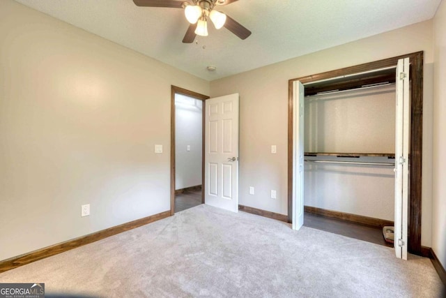 unfurnished bedroom featuring light colored carpet, ceiling fan, and a closet