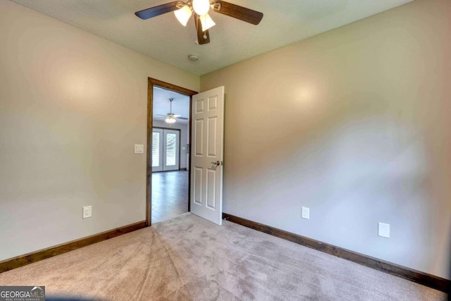 empty room featuring light colored carpet and ceiling fan