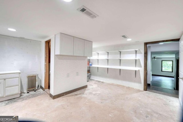 interior space with radiator and white cabinets