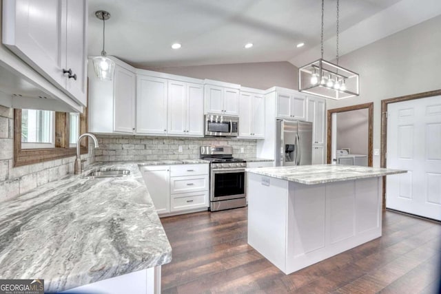 kitchen featuring hanging light fixtures, appliances with stainless steel finishes, a center island, and white cabinets