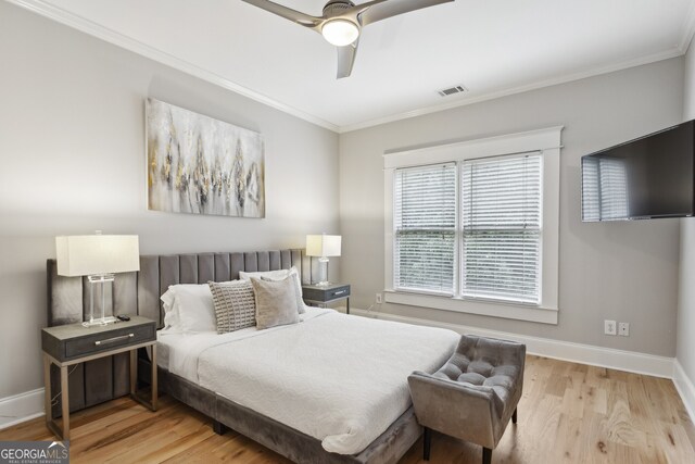 bedroom with ceiling fan, light wood-type flooring, and crown molding