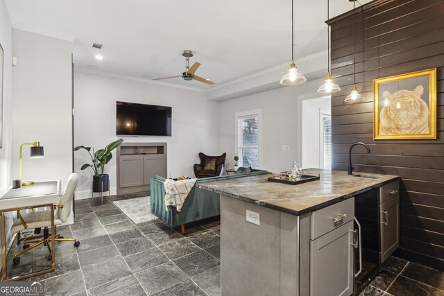 kitchen featuring dark tile patterned floors, wood walls, ceiling fan, hanging light fixtures, and gray cabinetry