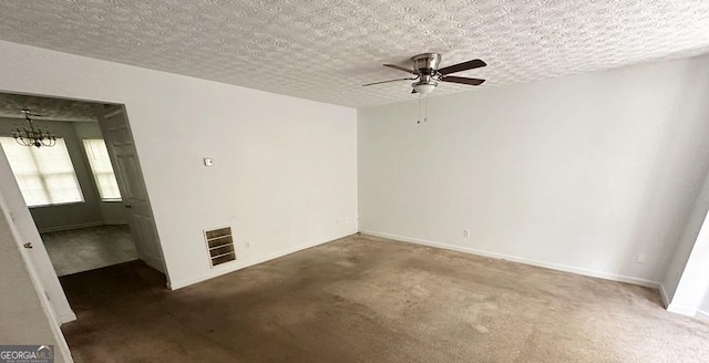 unfurnished room featuring ceiling fan with notable chandelier and a textured ceiling