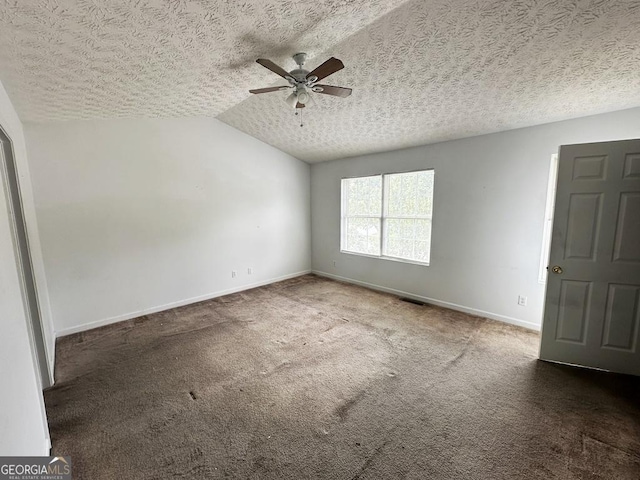 carpeted empty room with ceiling fan, vaulted ceiling, and a textured ceiling