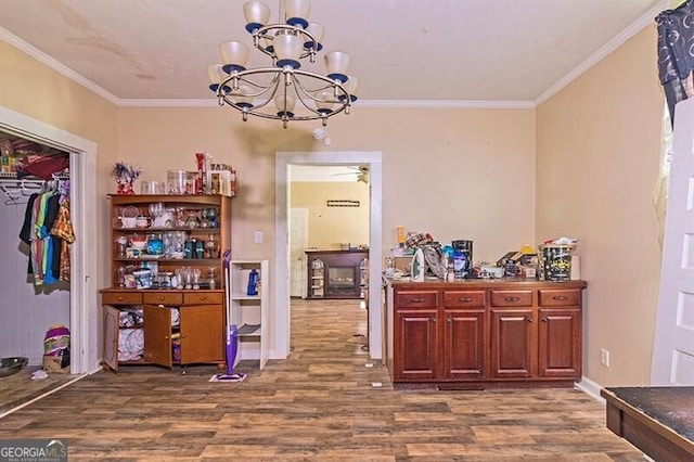 interior space featuring ceiling fan with notable chandelier, hardwood / wood-style flooring, and ornamental molding