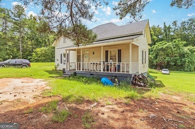 bungalow featuring a shingled roof, a front lawn, and a porch