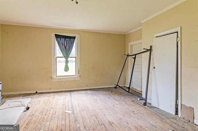 unfurnished bedroom featuring ornamental molding and light hardwood / wood-style flooring