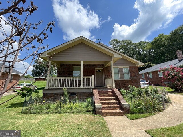 bungalow-style house with a porch and a front lawn