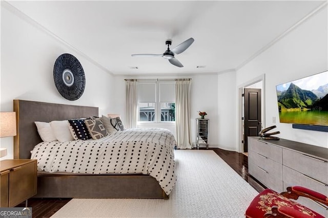 bedroom with ceiling fan, dark hardwood / wood-style floors, and crown molding