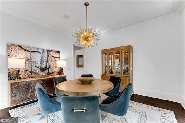 dining area featuring ornamental molding, hardwood / wood-style floors, and a chandelier