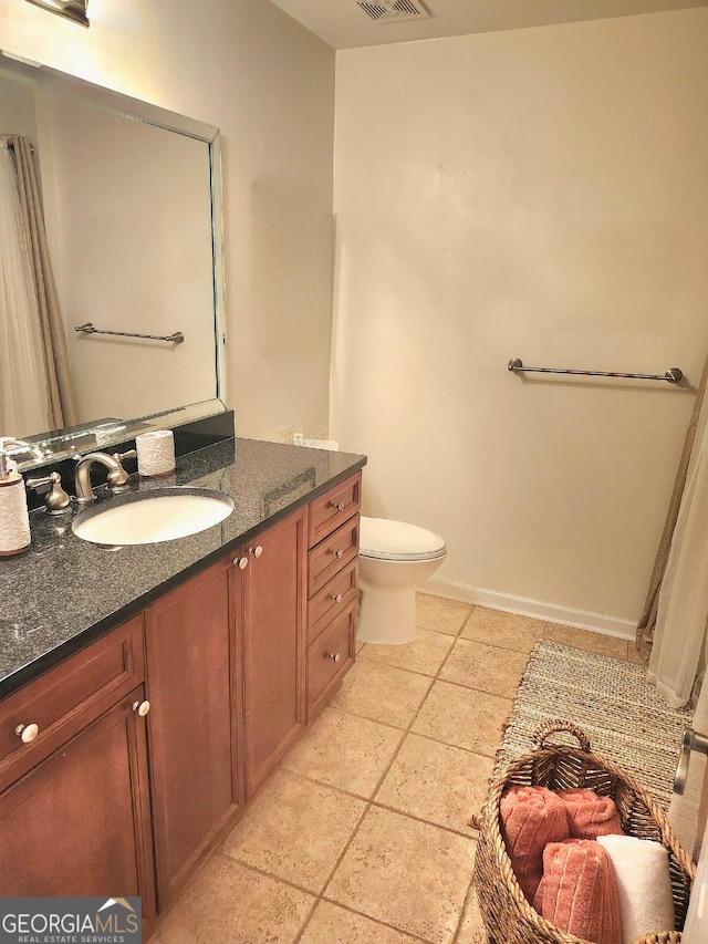 bathroom featuring vanity, toilet, and tile patterned flooring