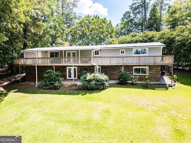 back of property with a lawn, a deck, and french doors