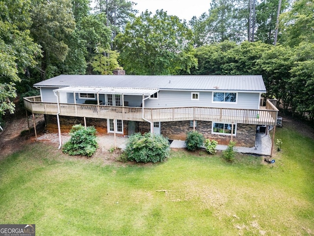 rear view of house with french doors, a lawn, and a wooden deck