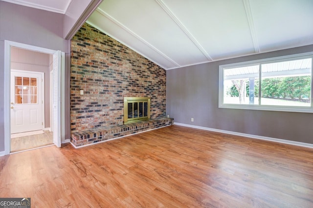 unfurnished living room featuring a brick fireplace, vaulted ceiling with beams, and light hardwood / wood-style flooring