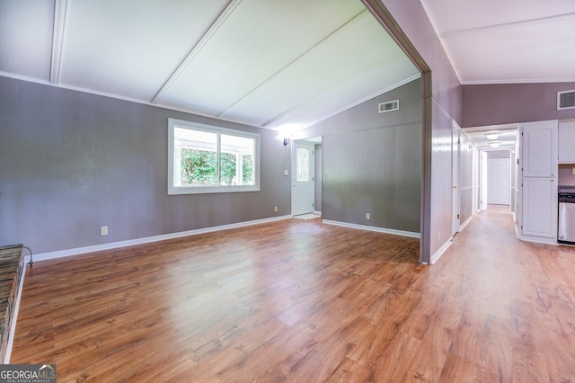 spare room featuring ornamental molding, light wood-type flooring, and lofted ceiling