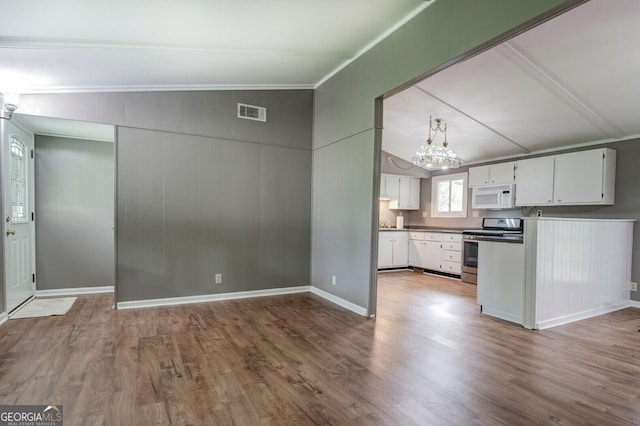 kitchen featuring lofted ceiling, hardwood / wood-style floors, white cabinets, and stainless steel range oven