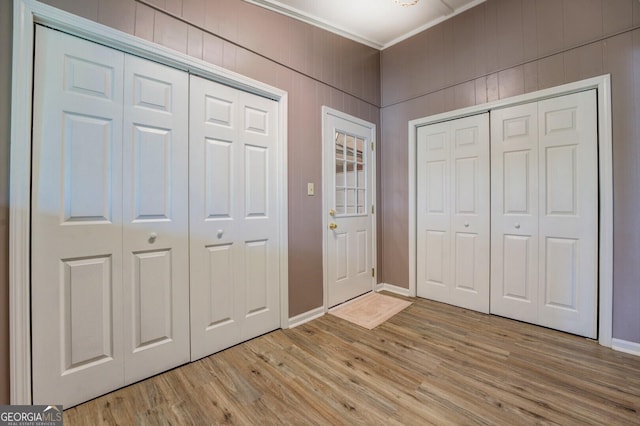 foyer entrance with light wood-type flooring and crown molding