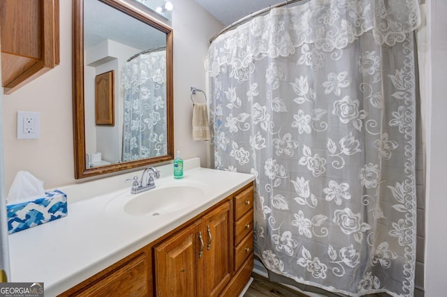 bathroom featuring walk in shower, vanity, and hardwood / wood-style flooring