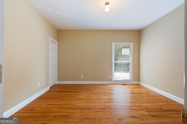 spare room featuring light wood-type flooring and baseboards