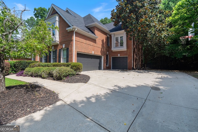 view of front of property featuring a garage, concrete driveway, and brick siding