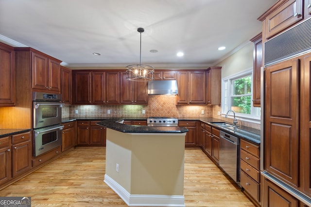 kitchen featuring pendant lighting, a kitchen island, light wood-type flooring, and stainless steel appliances