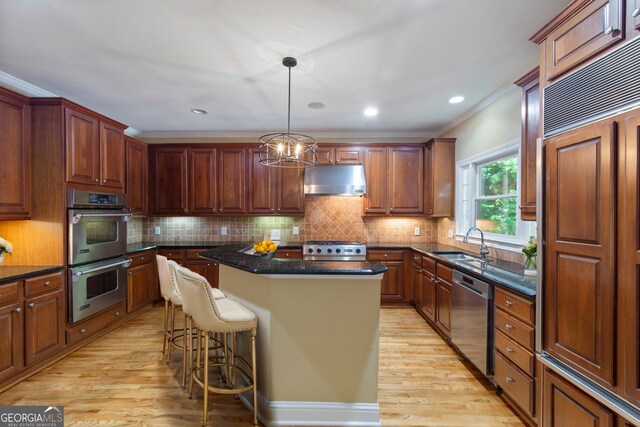 kitchen featuring a center island, decorative backsplash, light hardwood / wood-style flooring, and stainless steel appliances