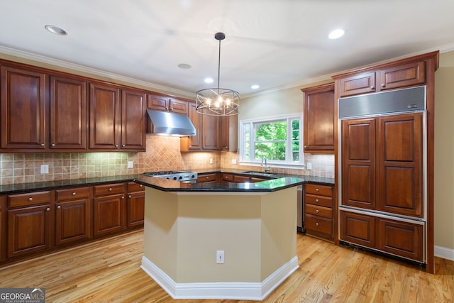 kitchen with light hardwood / wood-style flooring, a center island, decorative backsplash, and pendant lighting